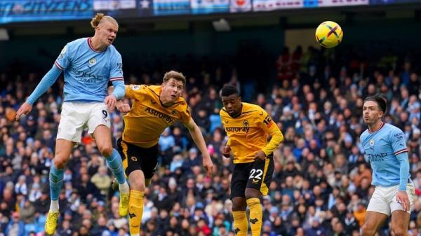 Nathan Collins of Wolves can o<em></em>nly watch as Erling Haaland rises to score his first