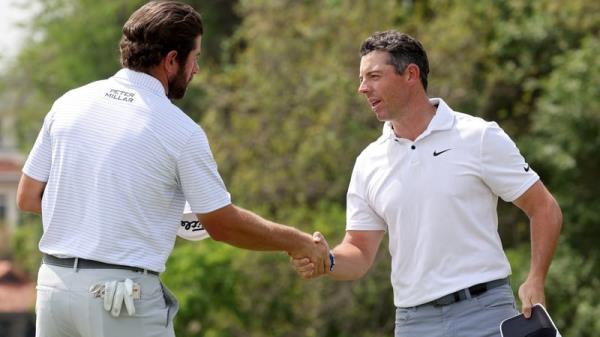 Cameron Young (L) shakes hands with Rory McIlroy