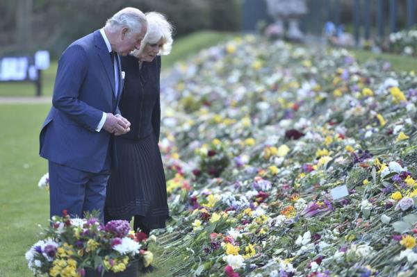 Charles and Camilla view flowers and messages left outside Buckingham Palace after the death of Charles' father, Prince Philip, in April 2021.