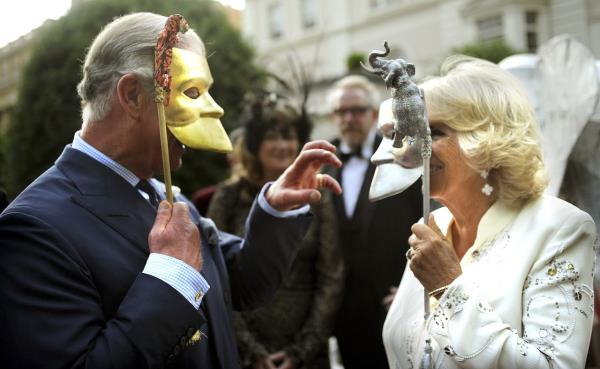 Charles and Camilla pose with masks as they host a charity reception in Lo<em></em>ndon in July 2013.