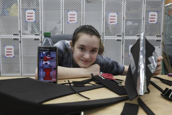 University of Illinois student Ellie Rebellón poses for a photograph while working on her prototype belted kingfisher mascot costume at the Siebel Center for Design on the university campus in Champaign on April 11, 2023.