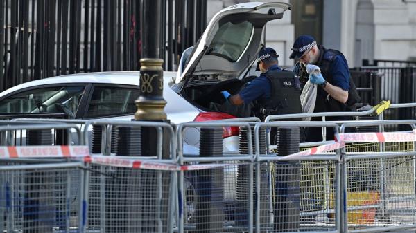 Police officers look at items inside the car that was involved in the incident on Thursday.