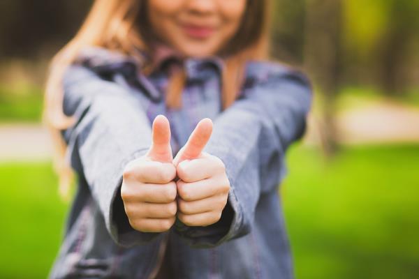 young woman giving thumbs up