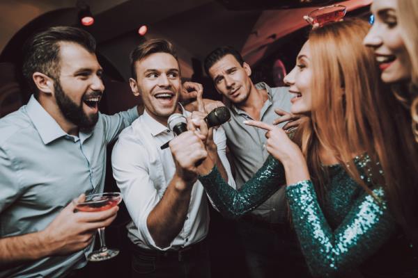 man singing karaoke while women watch, relatio<em></em>nship white lies